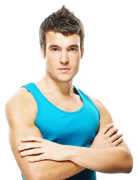 Portrait of young dark-haired serious man wearing blue t-shirt against white background.