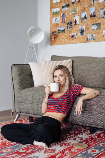 istock Close up young woman drinking tea at home 1332745856
