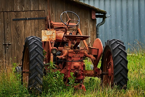 red old rusty tractor in a field