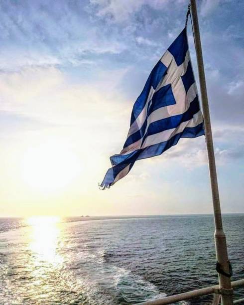 Flag of Greece flying in the Aegean Sea stock photo