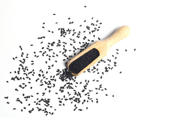 nigella sativa o comino negro en cuchara de madera aislada sobre fondo blanco - spice condiment spoon wooden spoon fotografías e imágenes de stock