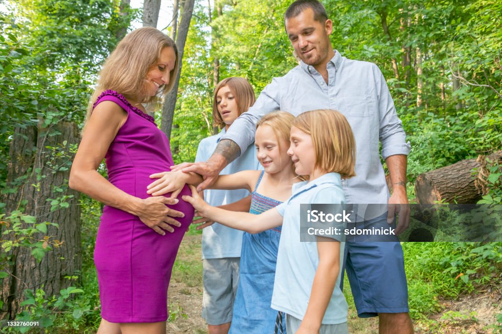 Father and Children Touching Pregnant Moms Belly A happy father and children touch the belly of their pregnant mother/wife. 40-44 Years Stock Photo