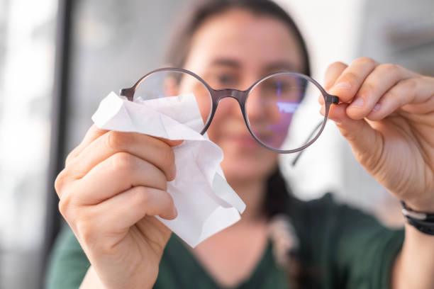 Woman cleaning eyeglasses stock photo
