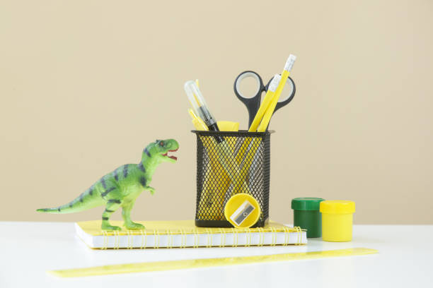 istock Education and back to school concept: notebooks with  school stationery and green dinosaur toy on the table. 1332763607