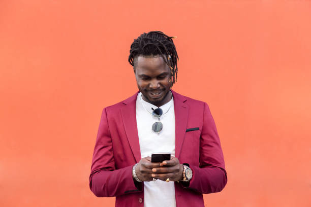 istock stylish black man typing message on a smart phone 1332763836