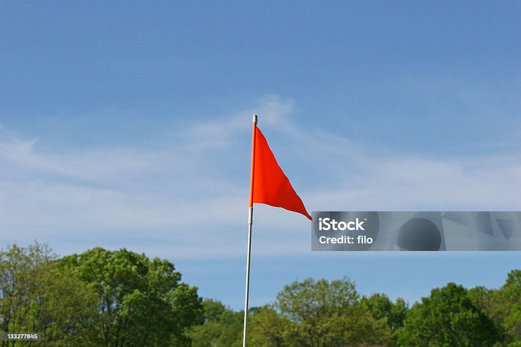Orange Flag An orange flag against a blue sky. Flag Stock Photo