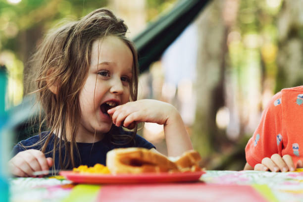 istock Girl Enjoys Campsite Lunch 1332780219