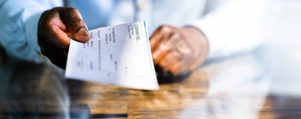 African Business Man Giving Paycheck African Business Man Giving Paycheck Or Payroll Cheque paycheck photos stock pictures, royalty-free photos & images