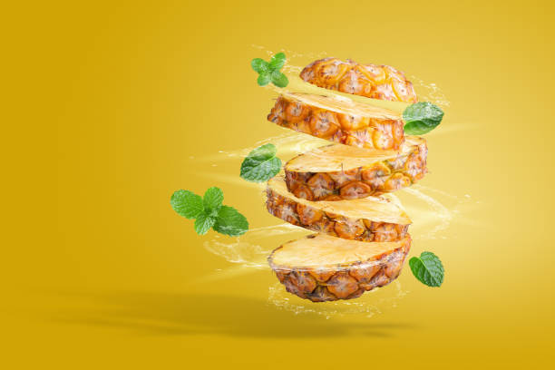 istock Water Splashing on Split Pineapple Fruit isolated over yellow background 1332796122