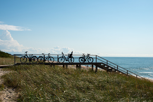 The silhouette of bikes standing in a row on the Baltic Sea coast. Vacation concept.