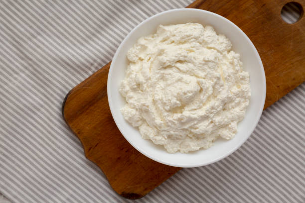istock Tasty Ricotta Cheese in a white bowl, top view. Overhead, from above, flat lay. Copy space. 1332803724