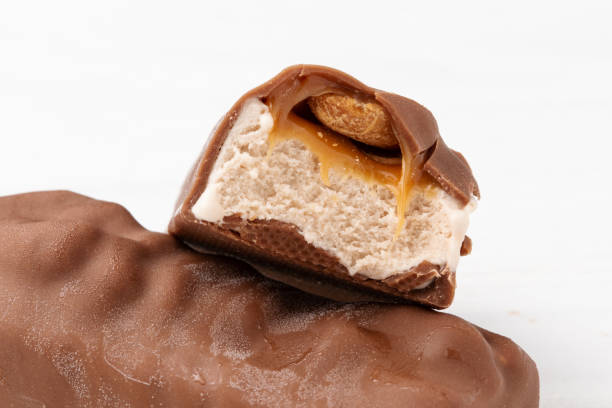 istock Two chocolate ice cream bars with caramel and peanuts on white background close up macro shot 1332804718