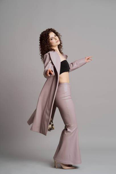 istock Woman in leather stylish clothes on studio gray background 1332805806