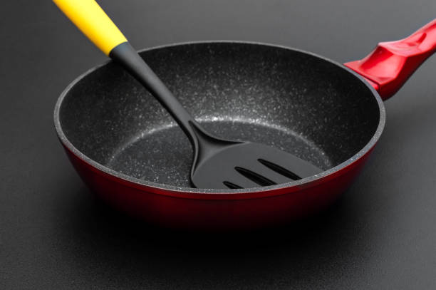 istock Frying pan with spade on black background. Close up. 1332807535