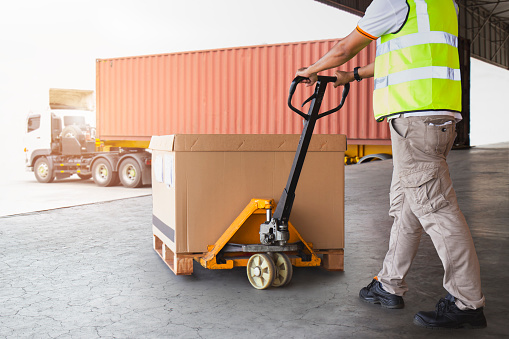 Warehouse Worker Unloading Package Box to Cargo Container. Delivery. Cargo Shipments. Shipping Warehouse Logistics and Transport.