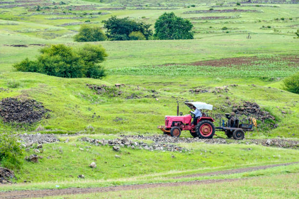 Pune, India - August 01 2021: A tractor towing a generator set in an open field near Pune India.