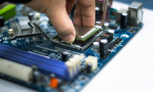 istock A young man is using his hand to pick up a PC computer CPU on a motherboard with many zips to upgrade a new CPU. 1332825017