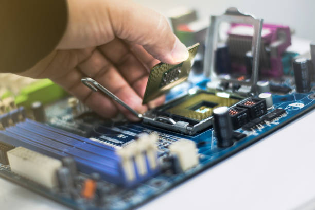 istock A young man is using his hand to pick up a PC computer CPU on a motherboard with many zips to upgrade a new CPU. 1332825028