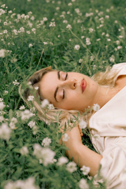 istock Woman lying on grass with flowers 1332828263