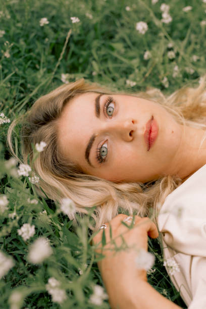 istock Woman lying on grass with flowers 1332828269
