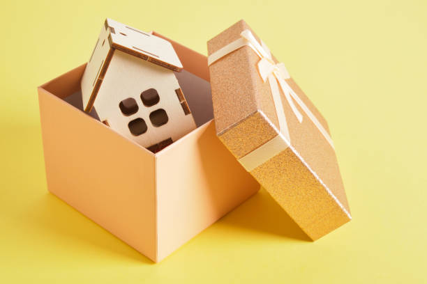 istock small house model in a gift box on a yellow background 1332829498
