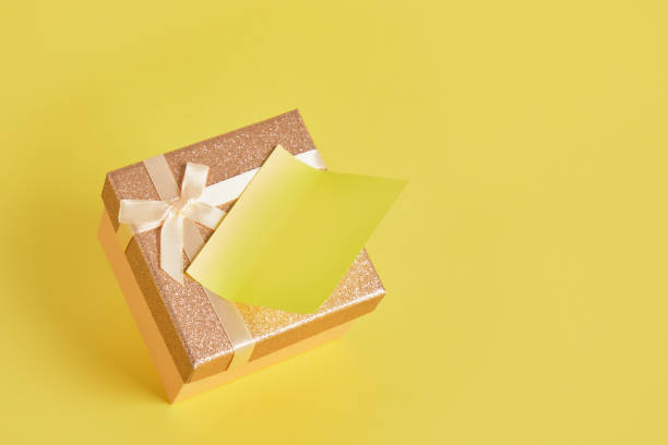 istock shiny pink square gift box on yellow background with note sticker glued to the lid 1332829514