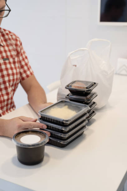 istock Young man sorting food delivery boxes at the kitchen 1332831872