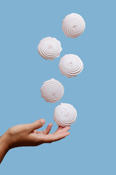 istock marshmallow floating in the air under hand against 1332833804
