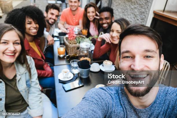Multiracial Friends Doing Selfie While Eating And Drinking Coffee At Vintage Bar Outdoor Focus On Right Man Face Stock Photo - Download Image Now