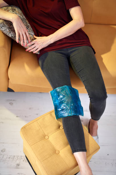 femme avec une blessure de douleur au genou à la maison en utilisant le pack de gel de glace. - ice women ice pack physical injury photos et images de collection
