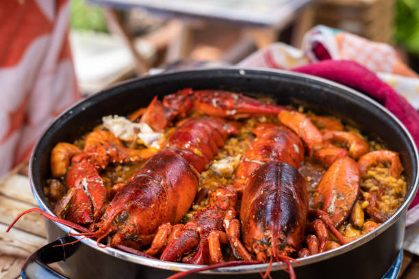 femme prenant de la paella espagnole avec du homard. gros plan - food rice lobster scampi photos et images de collection