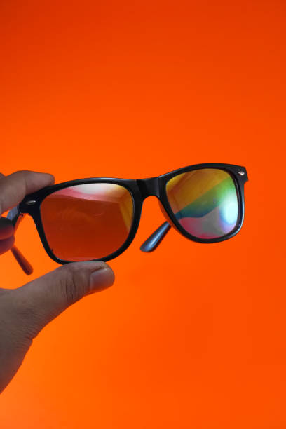 istock Close-up of hands holding rainbow glasses 1332845681