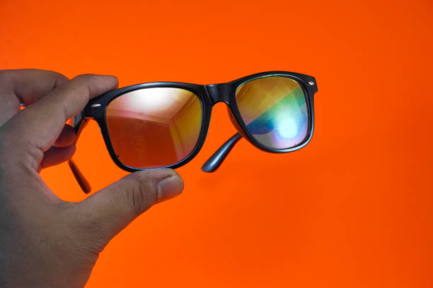 istock Close-up of hands holding rainbow glasses 1332845707