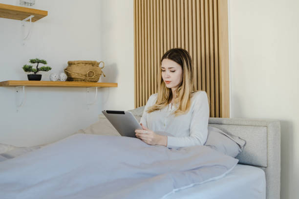 istock Young woman uses a digital tablet in bed 1332847144