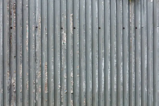 corrugated zinc-plated sheet fence with paper advertisements leftovers - full frame background and texture