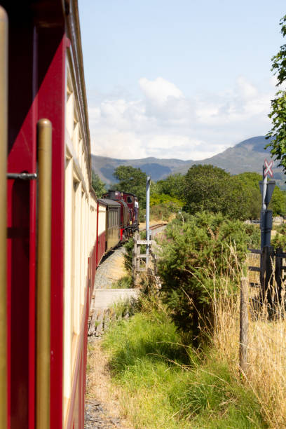 los observadores de trenes deleitan el tren de vapor welsh highland railway se acurruce a través del parque nacional de snowdonia en un día soleado de verano. - ffestiniog railway fotografías e imágenes de stock