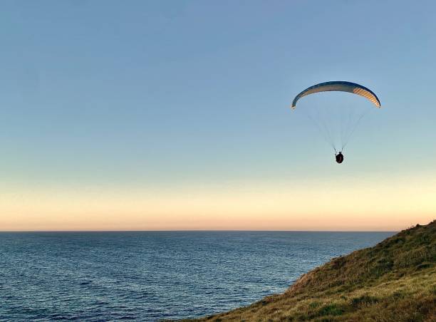 Paragliding off Headland at Sunset stock photo