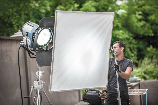 istock Behind the scene. Filmmaking lighting technician adjusting and setup lights 1332856315