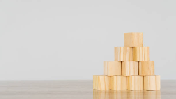 istock Empty wooden blocks on pyramid-like table, business growth concept on white background. 1332857396