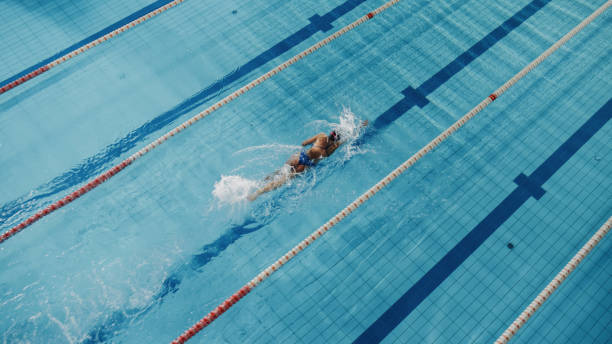 istock Beautiful Female Swimmer Using Front Crawl, Freestyle in Swimming Pool. Professional Athlete Training to Win Championship. Stylish Colors, High Angle Shot 1332857778