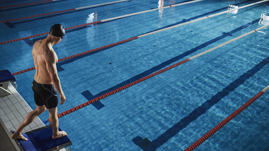 High quality stock photos of a father coaching his 12-year-old intermediate swimmer at an indoor public pool. Lessons include proper techniques to tread water, freestyle strokes, butterfly stroke as well as using the kick board. Techniques to more accurate strokes improving speed and mobility in the pool.