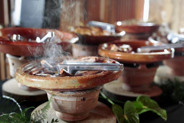 Cooked Belgian food placed in ceramic containers with a fire underneath to keep it warm.