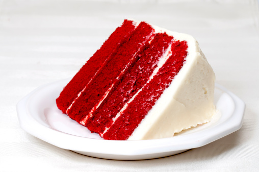 Slice of red velvet cake on plate.