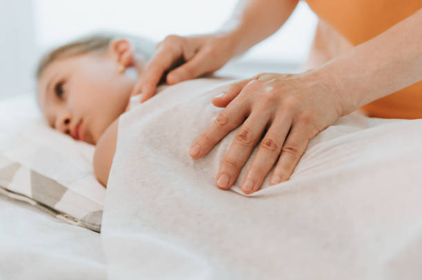 istock real doctor osteopath hands does physiological and emotional therapy for eight year old kid girl. pediatric osteopathy treatment session. alternative medicine. taking care of the child's health 1332874591