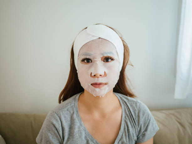 Woman doing face covered in moisturizing mask.