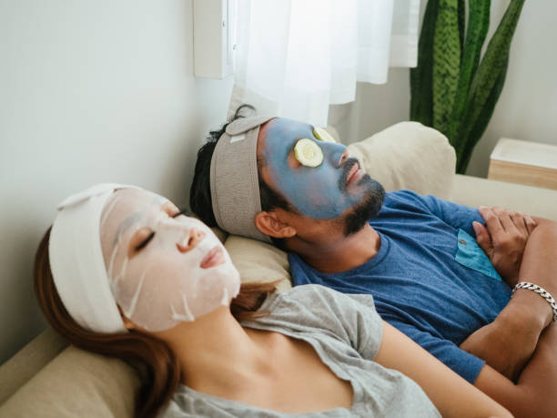 Happy couple doing facial mask. Happy time, couple applying facial mask during coronavirus quarantine at home. people covered in mud stock pictures, royalty-free photos & images