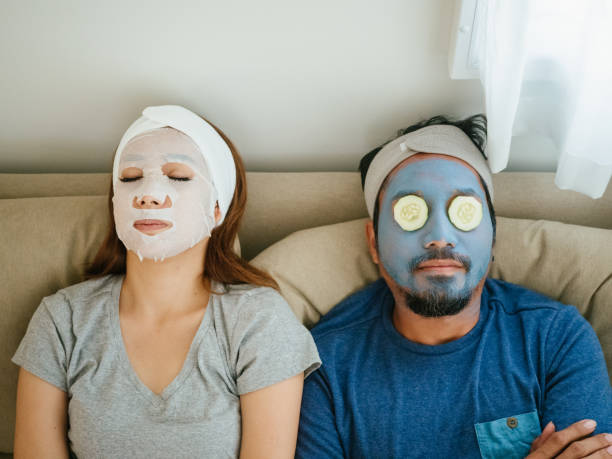 Happy couple doing facial mask. Happy time, couple applying facial mask during coronavirus quarantine at home. people covered in mud stock pictures, royalty-free photos & images