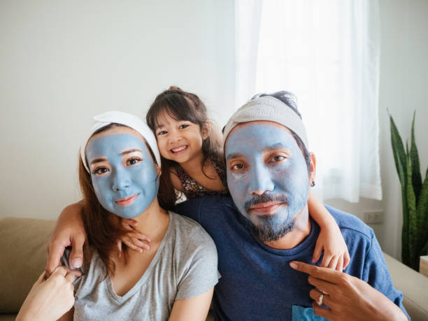Happy family doing facial mask. Happy time, family applying facial mask during coronavirus quarantine at home. people covered in mud stock pictures, royalty-free photos & images