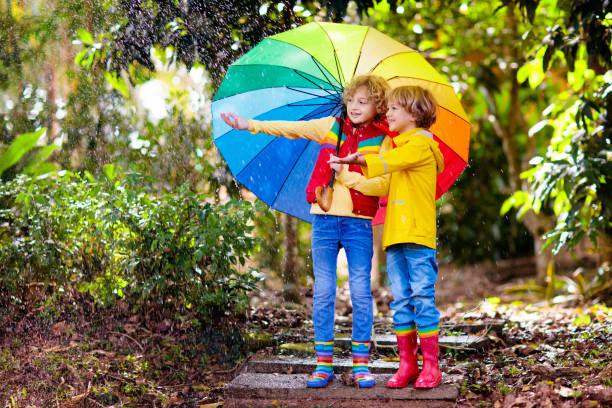 istock Child playing in autumn rain. Kid with umbrella. 1332880056