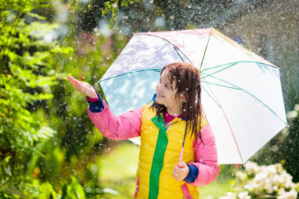 istock Child playing in autumn rain. Kid with umbrella. 1332880106